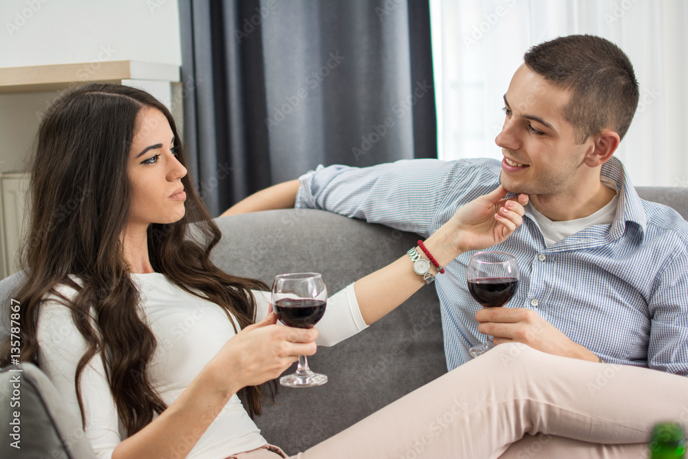 Young woman drinking wine and seducing her boyfriend at home. Young woman drinking wine and seducing her boyfriend at home.
