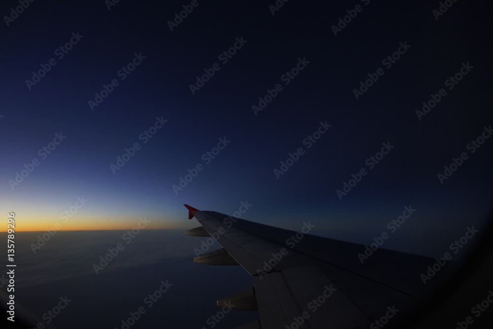wing of airplane flying on cloud in the afterglow wing of airplane flying on cloud in the afterglow