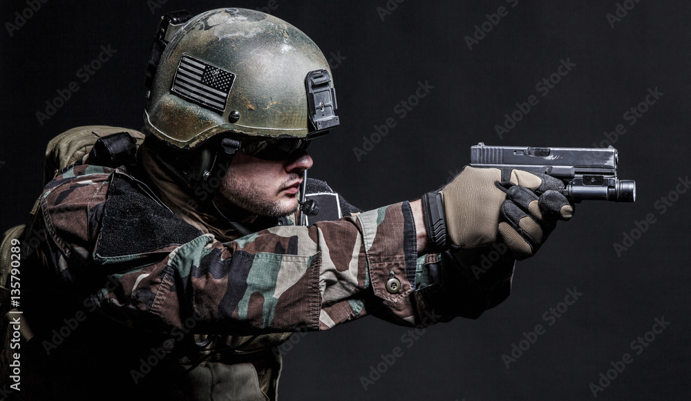 United states Marine Corps special operations command Marsoc raider with pistol. Studio shot of Marine Special Operator black background