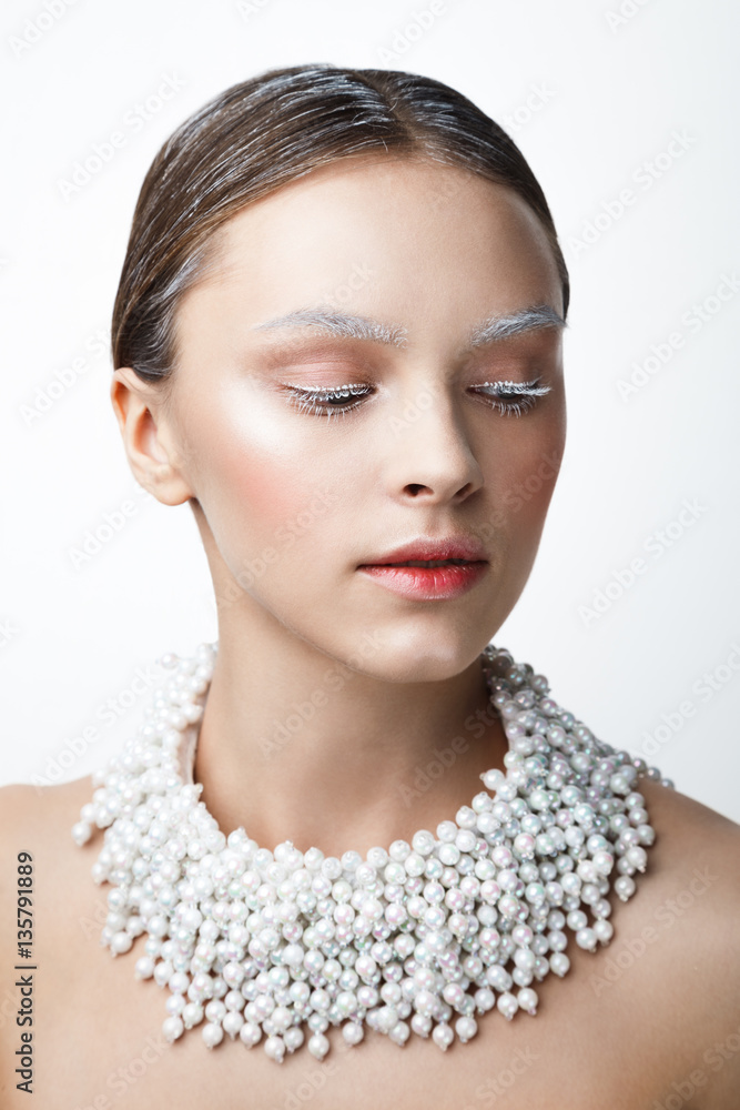 Beauty portrait of women with pearl necklace. White and col make