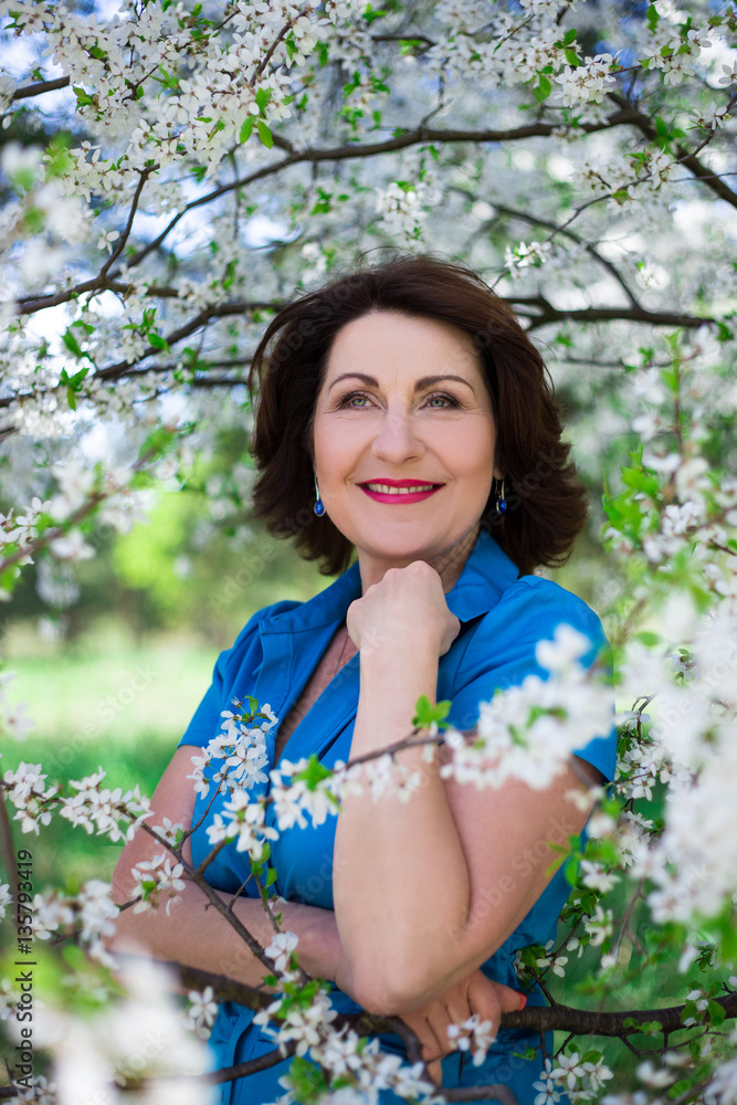 portrait of middle aged woman posing in cherry garden portrait of middle aged woman posing in cherry garden