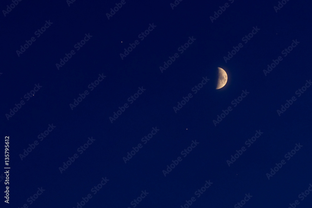 half moon and small stars on a blue night sky