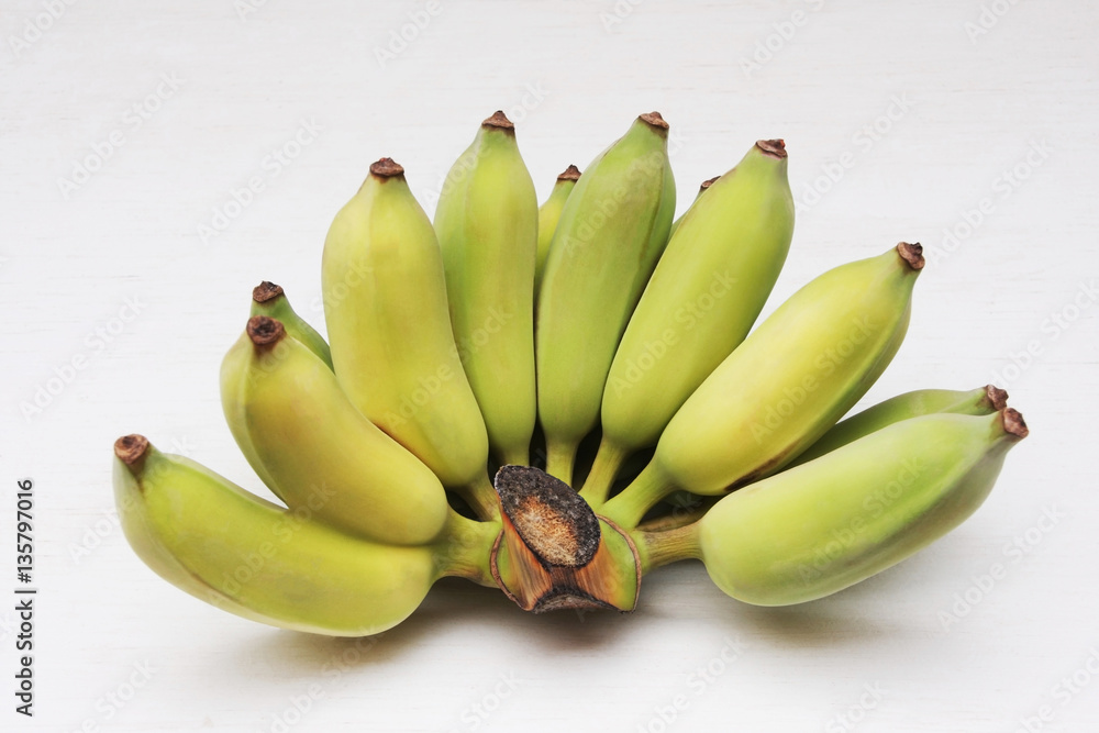 Bunch of Cultivated bananas or Thai bananas on white wooden back Bunch of Cultivated bananas or Thai bananas on white wooden back