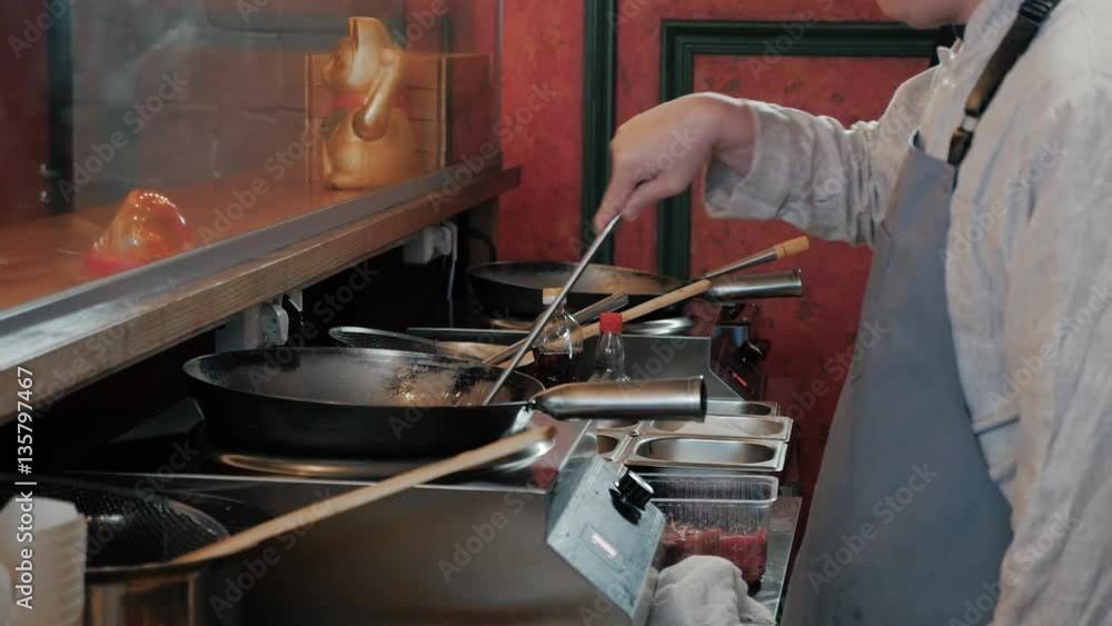 Chef Is Stirring Vegetables With Meat In Wok At Commercial Kitchen Chef Is Stirring Vegetables With Meat In Wok At Commercial Kitchen