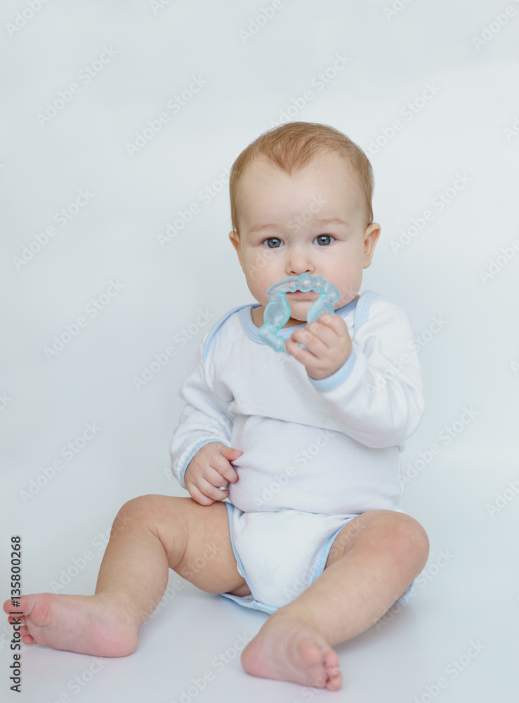 baby child lying on belly weared with teether in mouth. baby child lying on belly weared with teether in mouth.