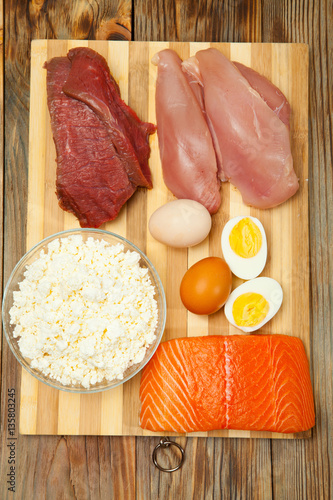 Protein diet, fish, cheese, eggs, meat and chicken on a wooden background