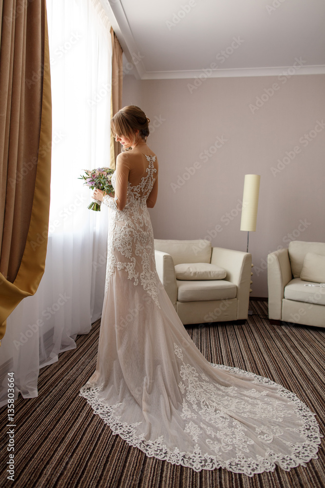 Fototapeta premium Elegant bride in wedding dress with long plume