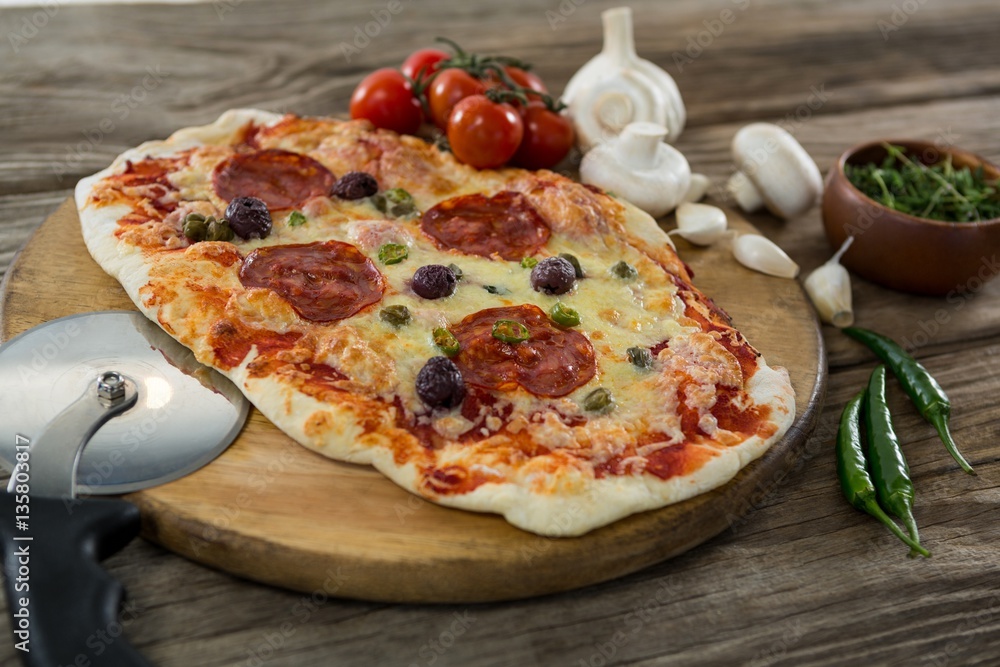 Various species with pizza and tomato on a wooden tray