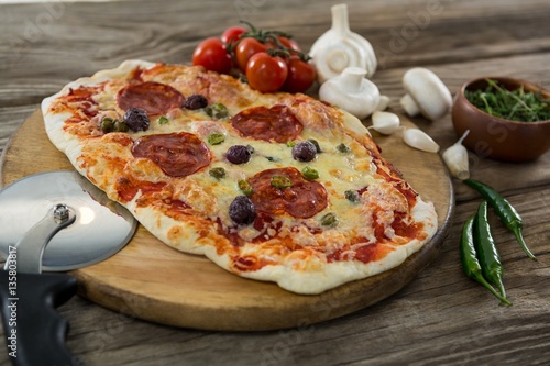 Various species with pizza and tomato on a wooden tray