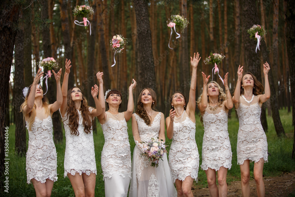 Bride and bridesmaids throwing wedding bouquets Bride and bridesmaids throwing wedding bouquets
