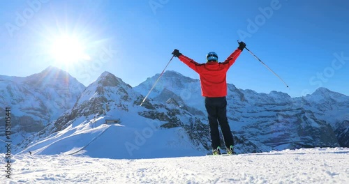 Happy Skier skiing and enjoying the sunny weather in Swiss Alps under Jungfrau, Monch and Eiger peaks photo