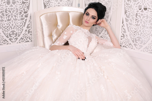 gorgeous bride with dark hair in luxuious wedding dress photo