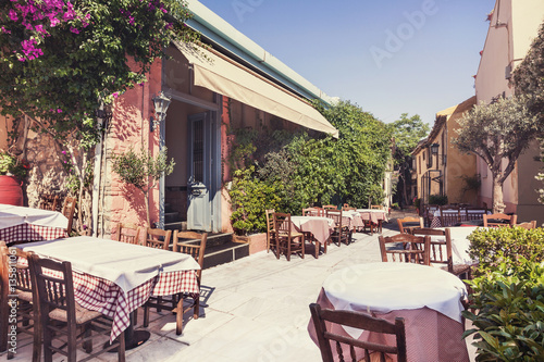 Fototapeta Naklejka Na Ścianę i Meble -  Charming street with cafe tables in the old district of Plaka in Athens, Greece