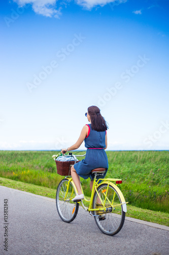 Fototapeta Naklejka Na Ścianę i Meble -  back view of woman riding retro bicycle in countryside