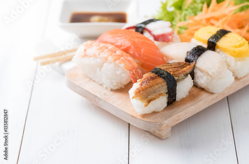 sushi with sauce and wasabi on wood plate