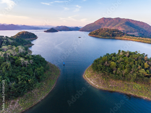 Aerial view of small island in water reservior with mountain bac