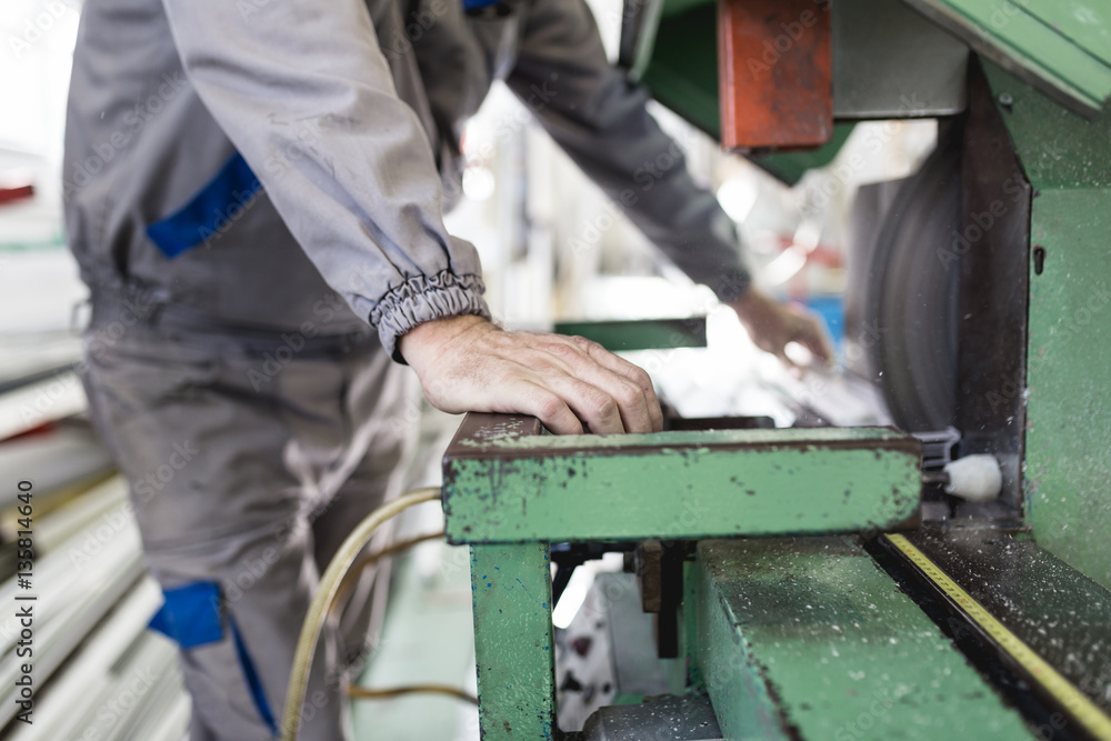 Factory for aluminum and PVC windows and doors production. Manual worker assembling PVC doors and windows. Selective focus. Factory for aluminum and PVC windows and doors production. Manual worker assembling PVC doors and windows. Selective focus.
