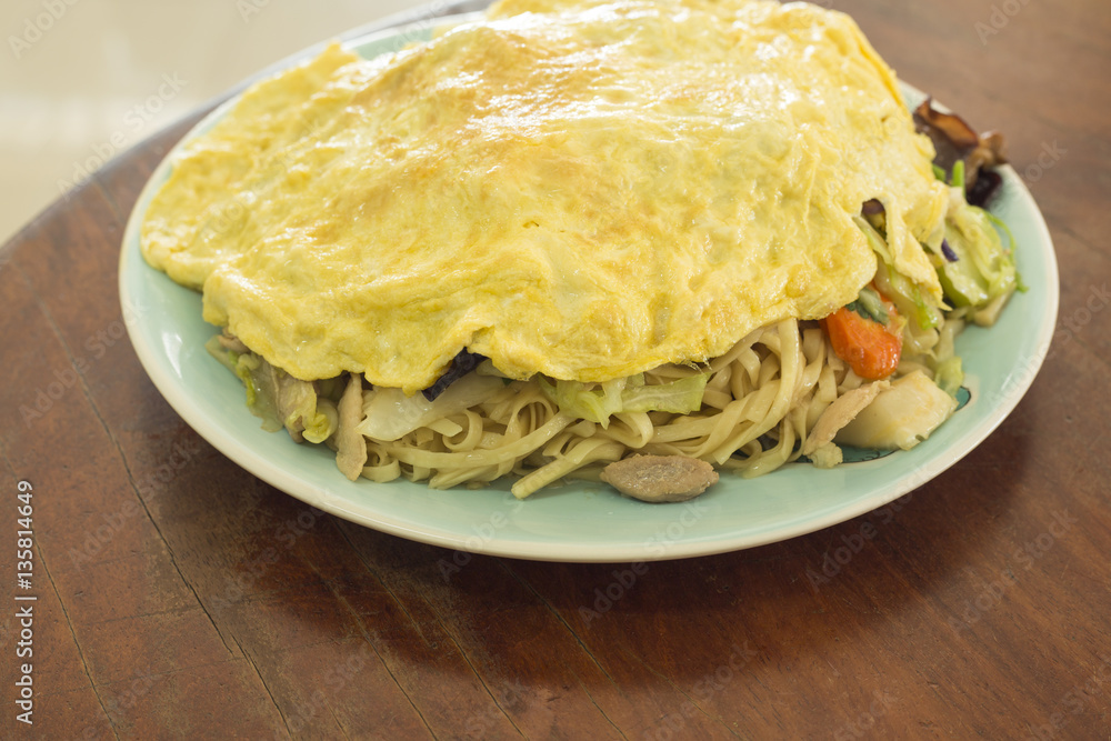 Myanmar food fried noodle cover omelet on wooden table Myanmar food fried noodle cover omelet on wooden table