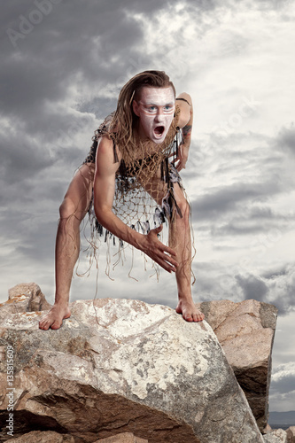 Wild man stands on a rock photo