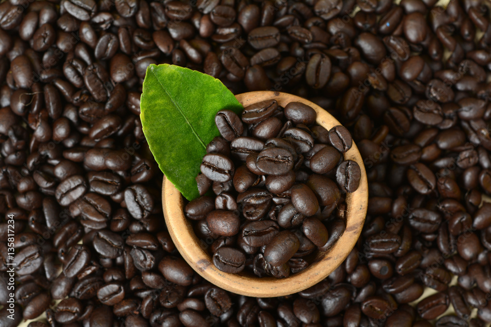 Fototapeta premium Coffee Beans in wood Bowl and Green leaf