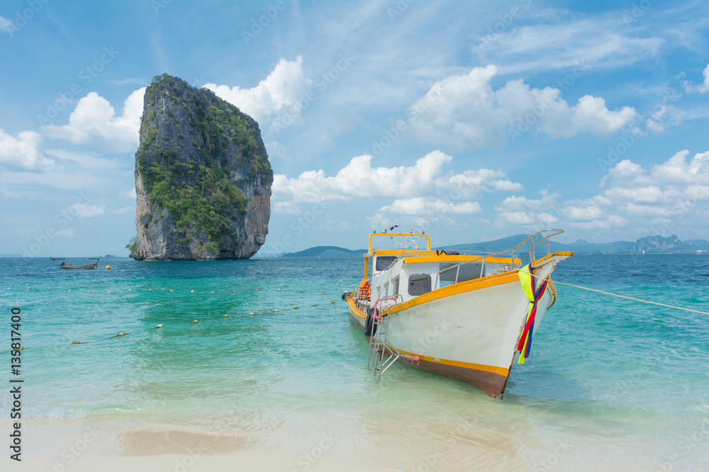 Touring boat landed on the white tropical beach ofPoda island, Krabi,Thailand.