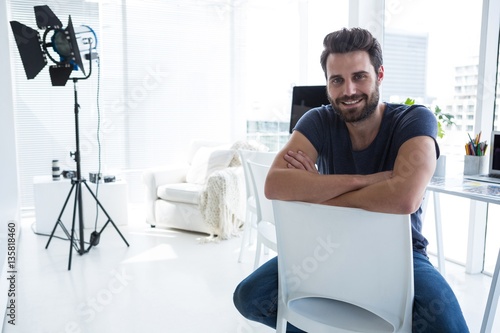 Happy male photographer sitting in studio