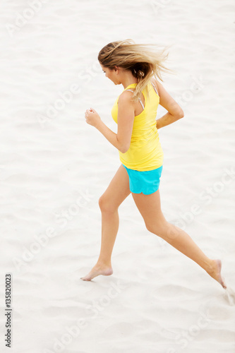 Young woman running on the beach © Piotr Marcinski