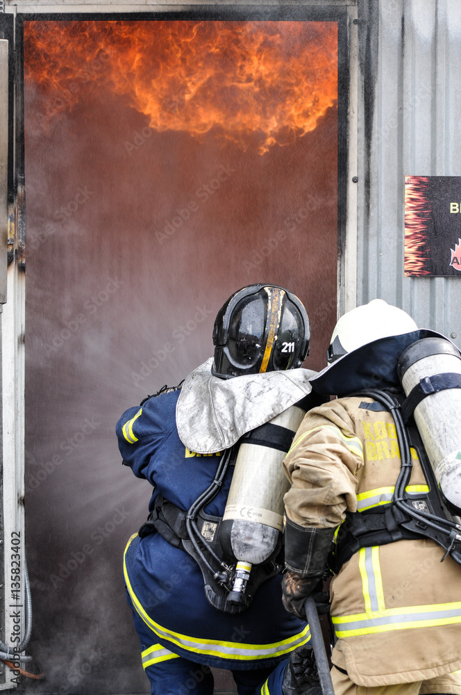 Naklejka premium Firemen enters burning building