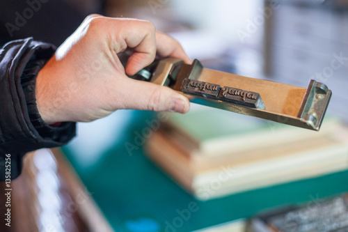 Hand with vintage type setting letters to print