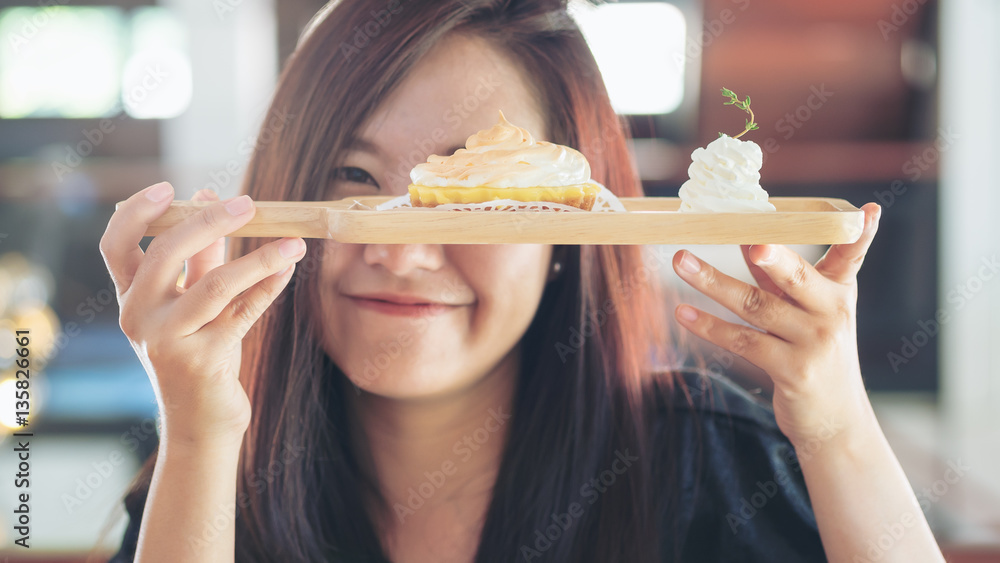 A Beautiful asian woman holding and showing with sweet dessertes with feeling happy and good lifestyle in the cafe A Beautiful asian woman holding and showing with sweet dessertes with feeling happy and good lifestyle in the cafe