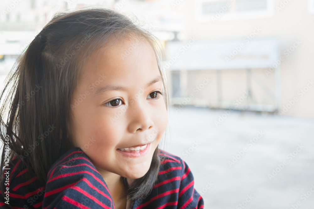 Adorable asian kid wear black and red striped shirt smiling in a restaurant. Adorable asian kid wear black and red striped shirt smiling in a restaurant.