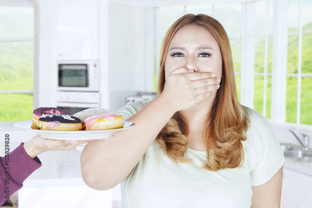 Beautiful woman closed mouth for donuts