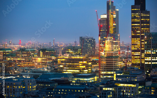 City of London at sunset with lights and reflection. View at the business and banking aria with modern skyscrapers 