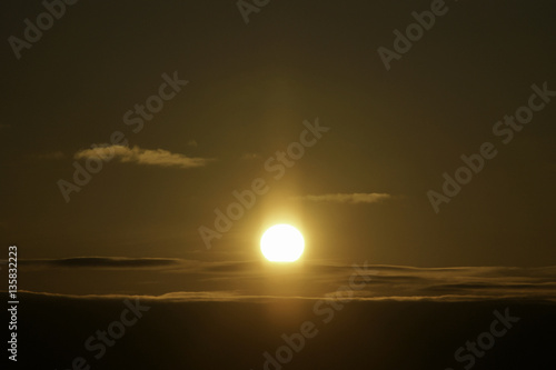 Full sun glowing above horizon during sunrise