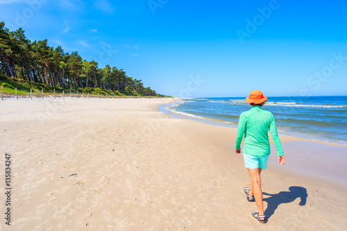 Young woman walking along Lubiatowo beach, Baltic Sea, Poland