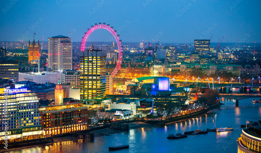 Fototapeta premium London at sunset with lights and reflection. View at the Westminster aria, London eye, River Thames, embankment and London bridge