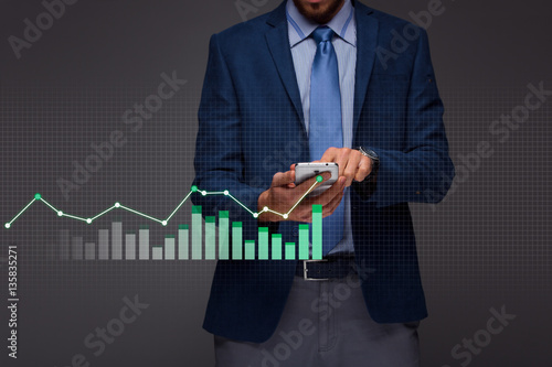 Businessman with growing chart, economy going up photo