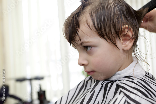 Barber cutting hair of child