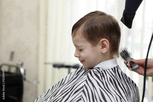 Serious kid getting haircut