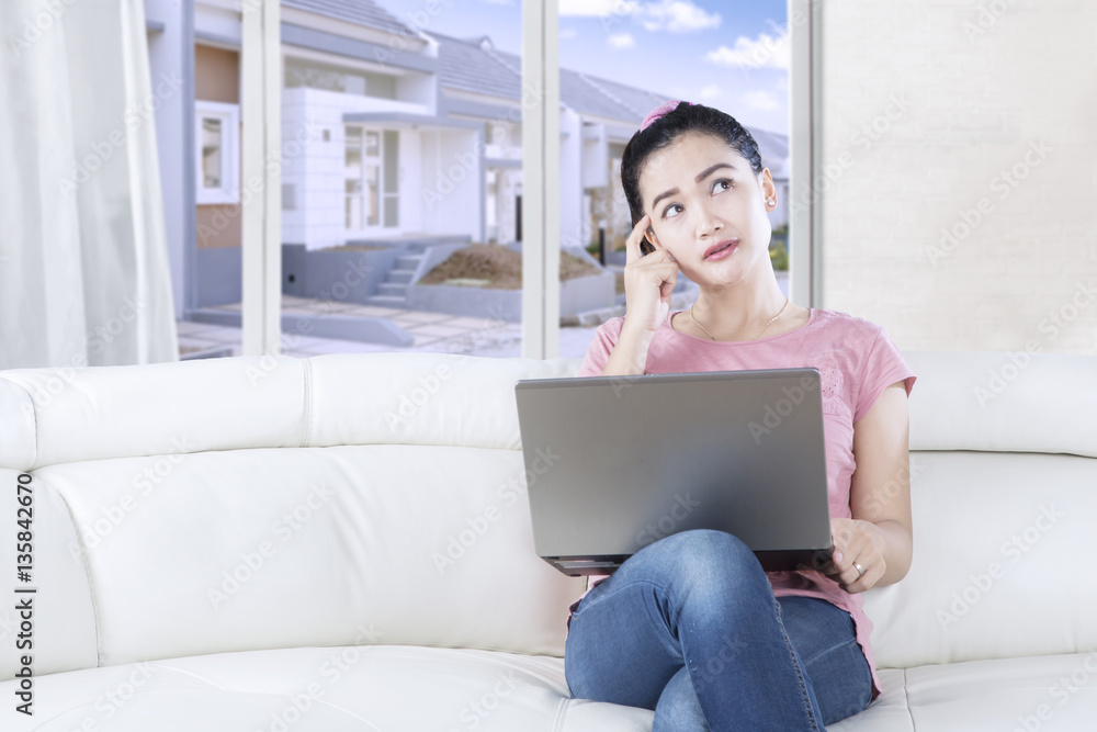 Naklejka premium Woman uses laptop and looking up