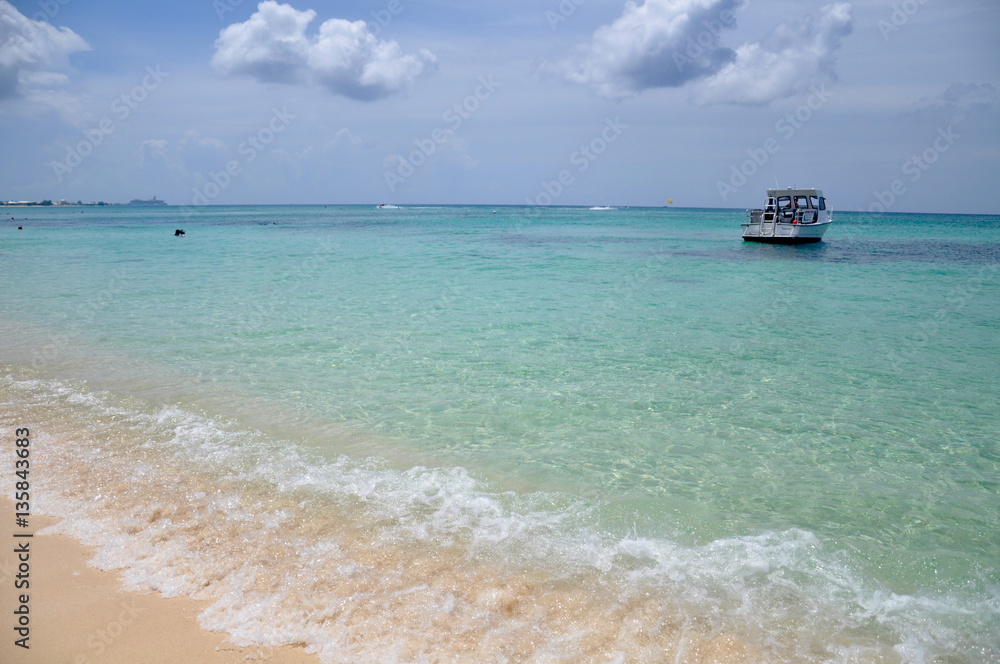 Tropical beach with clear water and boat in Cayman Island