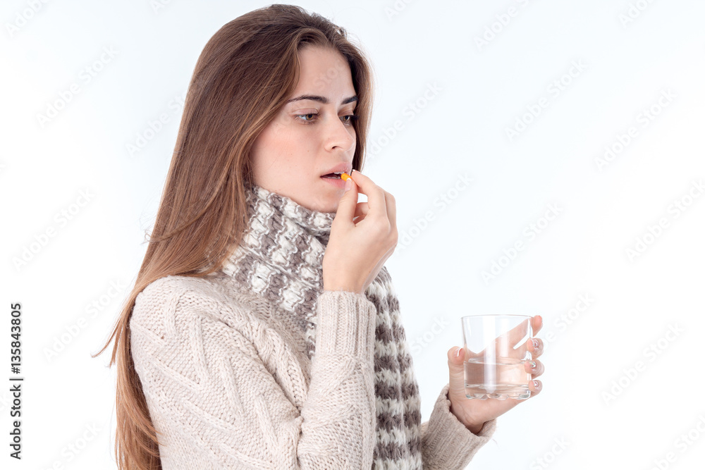 young girl got sick and drinking cures holding in her hand a glass of water young girl got sick and drinking cures holding in her hand a glass of water