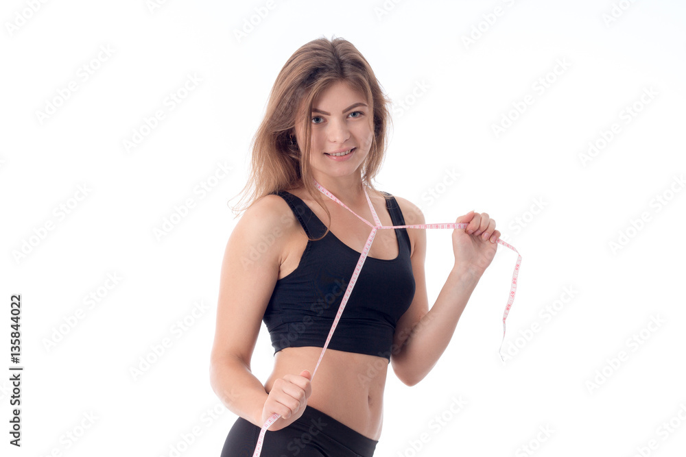 charming sports girl who is smiling and holding a measuring tape charming sports girl who is smiling and holding a measuring tape