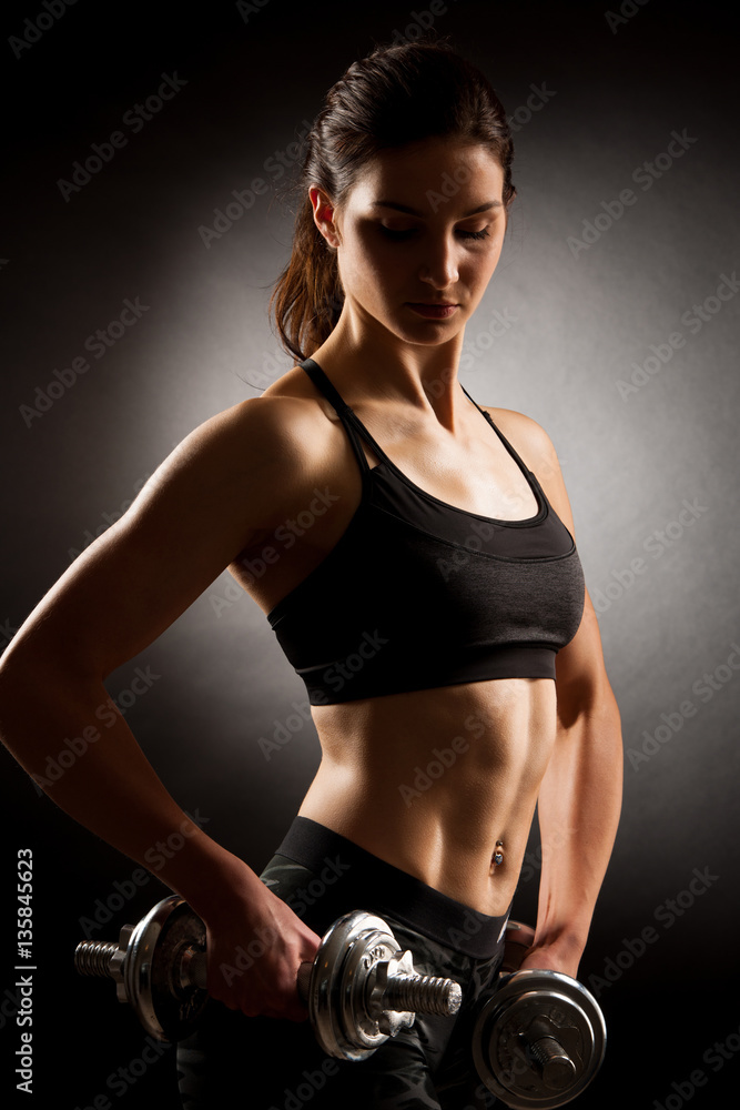 Atractive fit woman works out with dumbbells as a fitness concep Atractive fit woman works out with dumbbells as a fitness concep