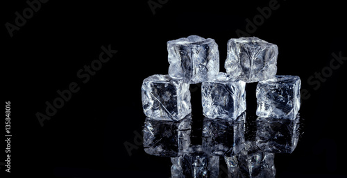 five ice cubes on black background
