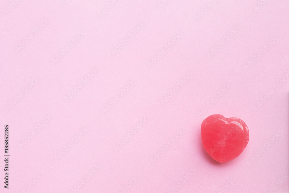 single Pink Valentine's day heart shape candy on empty pastel pi