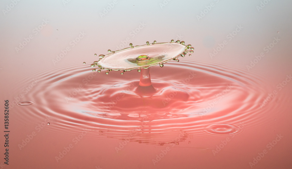 grüner Highspeedtropfen in rotem Wasser