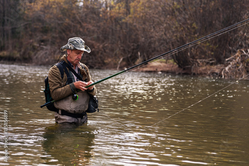 Fisherman standing in river when fishing for trout