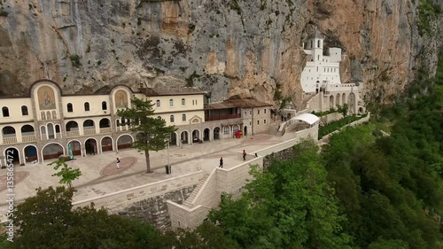 Camera review of upper Serbian Orthodox monastery of Ostrog with walking visitors. Aerial view. The Monastery of Ostrog is monastery of Serbian Orthodox Church, Montenegro
