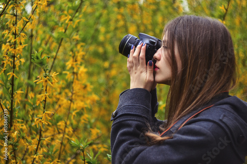 Obraz na plátně Girl taking photo of blossoming tree